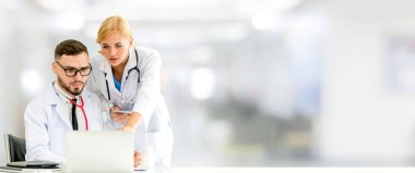 Doktor hastanede başka bir doktor ile bir tartışma yaparken ofiste dizüstü bilgisayarla çalışma. Tıbbi sağlık ve doktor hizmeti.