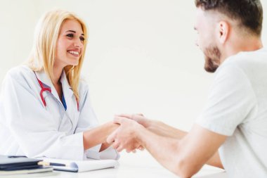 Kadın doktor hastane office odasında erkek hasta ile karşılıklı yapıyor. Sağlık ve Medikal hizmet meslekleri.