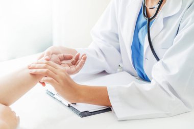 Kadın doktor hastane ofiste bayan hasta için eller tarafından hasta darbe incelenirken konuşuyor. Sağlık ve tıbbi hizmet.