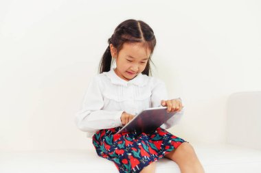 Tablet bilgisayar ile beyaz arka plan üzerinde küçük mutlu çocuk. Çocukluk yaşam tarzı.