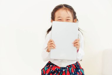 Tablet bilgisayar ile beyaz arka plan üzerinde küçük mutlu çocuk. Çocukluk yaşam tarzı.