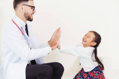 Little kid visit doctor in hospital office. The kid is happy and not afraid of the doctor. Medical and children healthcare concept. clipart