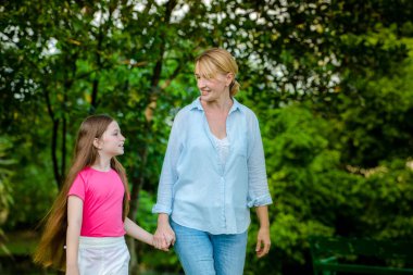 Rahat mutlu anne ve küçük çocuk kız açık havada genel Park. Ebeveyn ve çocuk kavramı.