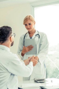 El sıkışma başarı ve profesyonel sağlık personeli ekip çalışması gösteren başka bir doktora veren hastanede doktor.