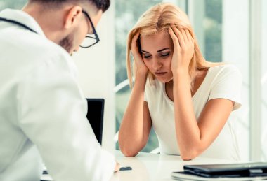 Erkek doktor hastane Office ciddi bayan hasta konuşuyor. Sağlık ve tıbbi hizmet.