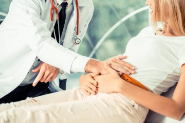 Erkek doktor konuşuyor ve Bayan hasta hastane ofisinde inceleyerek. Sağlık ve tıbbi hizmet.