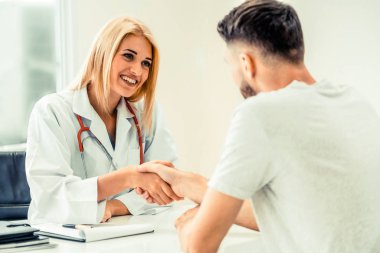 Kadın doktor hastane office odasında erkek hasta ile karşılıklı yapıyor. Sağlık ve Medikal hizmet meslekleri.