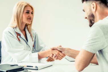 Kadın doktor hastane office odasında erkek hasta ile karşılıklı yapıyor. Sağlık ve Medikal hizmet meslekleri.