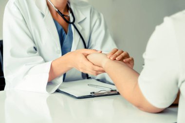 Kadın doktor hastane ofiste bayan hasta için eller tarafından hasta darbe incelenirken konuşuyor. Sağlık ve tıbbi hizmet.