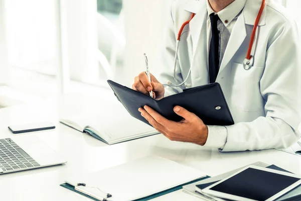 Doctor Leyendo Mientras Escribe Una Nota Libro Oficina Hospital Concepto — Foto de Stock