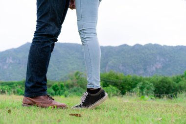Mutlu çift tepelerde yeşil çim alandaki romantik bir yürüyüşe çık. Seyahat ve balayı konsepti.