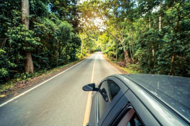 Orman Otoban yolu üzerinde yaz aylarında siyah araba yan görünüm. Seyahat ve kavramı.