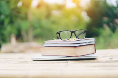 Yumuşak odak retro tarzı kitap ve göz gözlük doğa arka plan ile. Okuma ve eğitim kavramı.