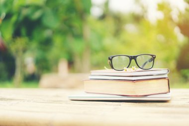 Yumuşak odak retro tarzı kitap ve göz gözlük doğa arka plan ile. Okuma ve eğitim kavramı.