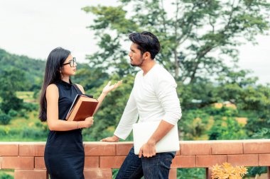 İki öğrenci kitap ve üniversitede konuşurken laptop ile. Eğitim kavramı kolej.