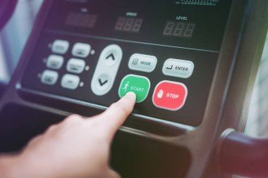 Koşmaya başla - koşu bandı kontrol panelindeki Başlat düğmesine basarak el. Sağlıklı yaşam konsepti.