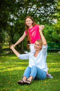 Rahat mutlu anne ve küçük çocuk kız açık havada genel Park. Ebeveyn ve çocuk kavramı.