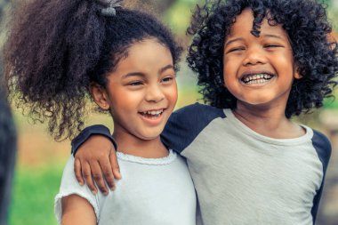 Mutlu erkek ve kız parkta. İki Afro-Amerikan çocuk birlikte bahçede.