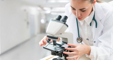 Bilim adamı araştırmacı laboratuarda mikroskop kullanarak. Tıbbi sağlık teknoloji ve ilaç araştırma ve geliştirme kavramı.