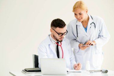 Doktor hastane ofis dizüstü bilgisayar masanın üzerinde başka bir doktor hasta sağlık hakkında tartışma ile çalışma.