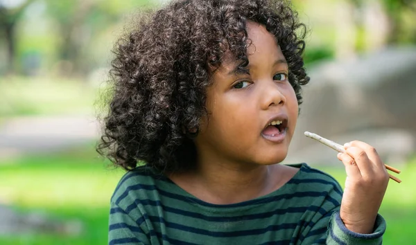 Felice Bambino Afroamericano Che Mangia Snack Stick Nel Parco Concetto — Foto Stock