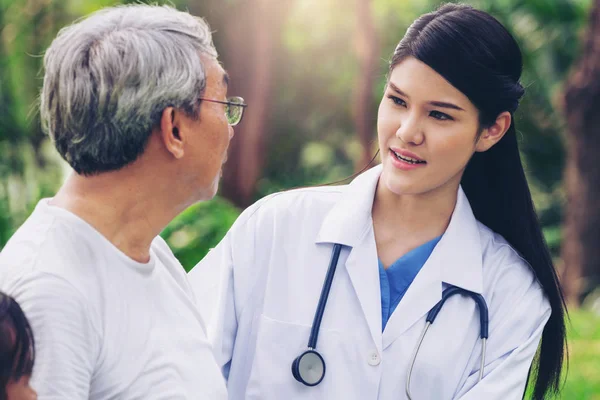 Friendly doctor taking care of senior man in the hospital garden. Medical and healthcare doctor service concept.