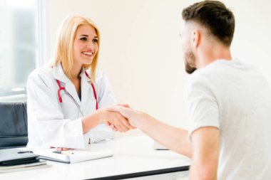Kadın doktor hastane office odasında erkek hasta ile karşılıklı yapıyor. Sağlık ve Medikal hizmet meslekleri.