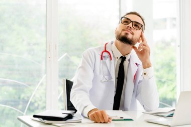 Hastanede ofis masasında çalışırken düşünme doktor. Tıbbi ve sağlık kavramı.