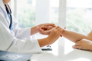 Kadın doktor hastane ofiste bayan hasta için eller tarafından hasta darbe incelenirken konuşuyor. Sağlık ve tıbbi hizmet.