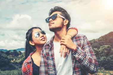 Mutlu çift tepelerde yeşil çim alandaki romantik bir yürüyüşe çık. Seyahat ve balayı konsepti.