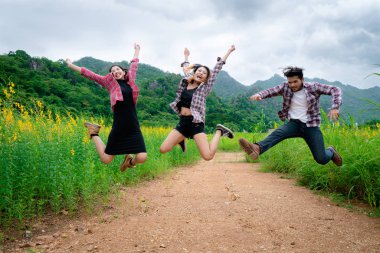 Gençlerin grup dağ ve doğa iz seyahat ederken havada atlama mutlu. Seyahat ve açık hava yaşam tarzı kavramı.