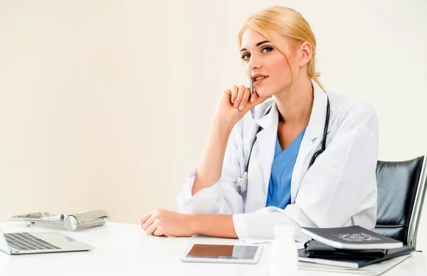 Woman doctor in hospital or healthcare institute working on medical report at office table.