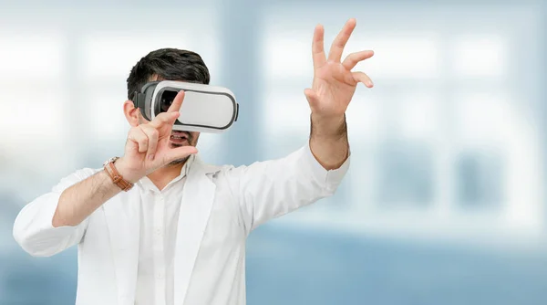 Male doctor wearing VR virtual reality goggles in the hospital. Medical technology research institute and doctor staff service concept.