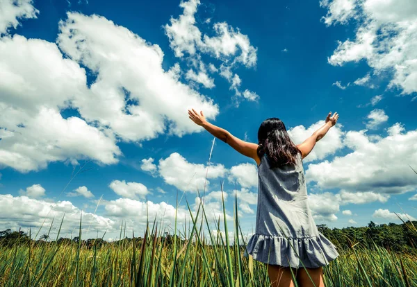 夏の日の晴れた青空に腕を広める緑の草の牧草地に若い美しい女性 逃走と瞑想の概念 — ストック写真