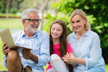 Mutlu aile dizüstü bilgisayar birlikte bahçe parkta yaz aylarında kullanma.. Çocuk eğitim ve aile etkinlikleri kavramı.