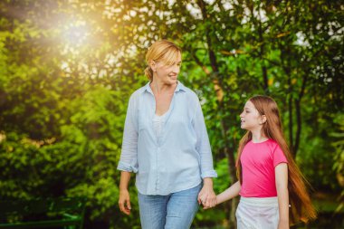 Rahat mutlu anne ve küçük çocuk kız açık havada genel Park. Ebeveyn ve çocuk kavramı.
