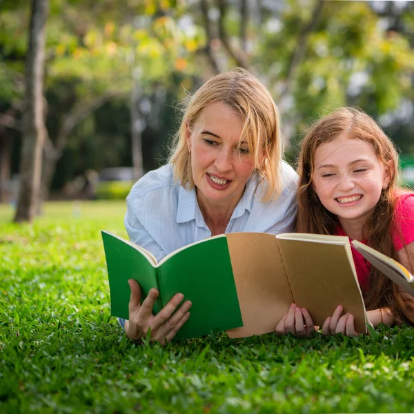 幸福的家庭一起读书 躺在公共公园的绿草上 小女孩的孩子学习与母亲在户外花园 教育和家庭生活方式 — 图库照片