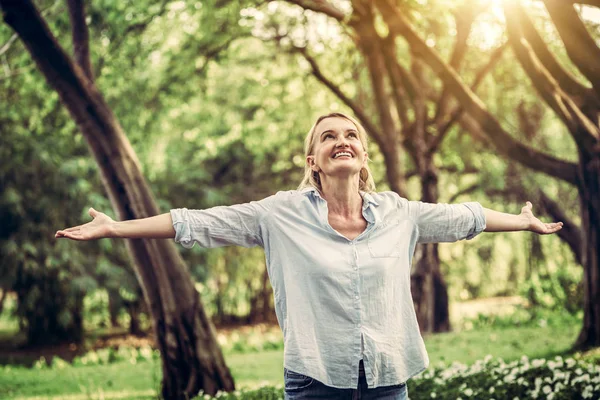 Parkta dans mutlu orta yaşlı kadın portresi. Kadın mutlulukla gülümsüyor. Emeklilik kavramı.
