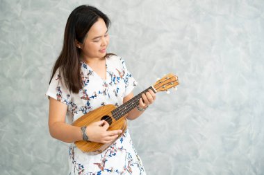 Ukulele oynama ve ses stüdyosunda bir şarkı söylerken mutlu kadın müzisyen. Müzik yaşam tarzı konsepti.