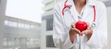 Kırmızı bir kalp Hastanesi ofiste tutan doktor. Tıbbi doktor ve sağlık personeli hizmet anlayışı.