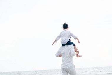 Mutlu baba oğlu yaz aylarında boyun tropikal bir kum Plajı üzerinde taşıyan.