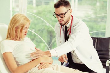 Erkek doktor konuşuyor ve Bayan hasta hastane ofisinde inceleyerek. Sağlık ve tıbbi hizmet.