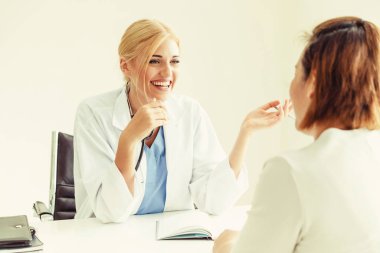 Kadın doktor konuşuyor ve Bayan hasta hastane ofisinde inceleyerek. Sağlık ve tıbbi hizmet.