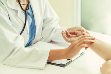 Kadın doktor hastane ofiste bayan hasta için eller tarafından hasta darbe incelenirken konuşuyor. Sağlık ve tıbbi hizmet.