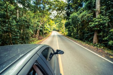 Orman Otoban yolu üzerinde yaz aylarında siyah araba yan görünüm. Seyahat ve kavramı.