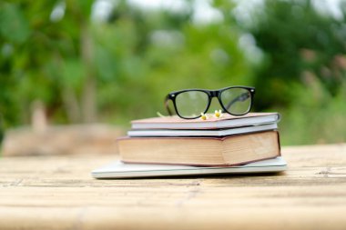 Yumuşak odak retro tarzı kitap ve göz gözlük doğa arka plan ile. Okuma ve eğitim kavramı.