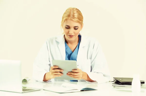 Woman doctor in hospital or healthcare institute working on medical report at office table.