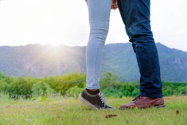 Mutlu çift tepelerde yeşil çim alandaki romantik bir yürüyüşe çık. Seyahat ve balayı konsepti.