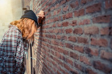 Genç kadın yalnız eski şehirde tuğla duvara üzgün depresif. Eğitim ve aile başarısızlık kavramı.