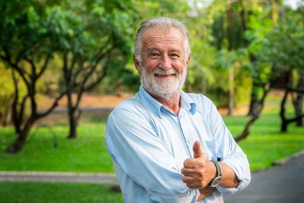 公園に立って幸せな年配の男性の肖像画 高齢者の健康と退職後の概念 — ストック写真